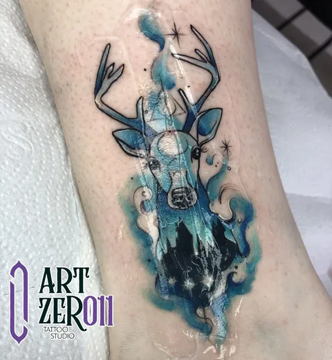 Cervo em aquarela azul, com a silhueta de um castelo e estrelas dentro do corpo