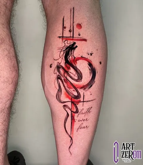 Dragão em traço preto sobre pinceladas vermelhas, com a frase "faith over fear", na perna