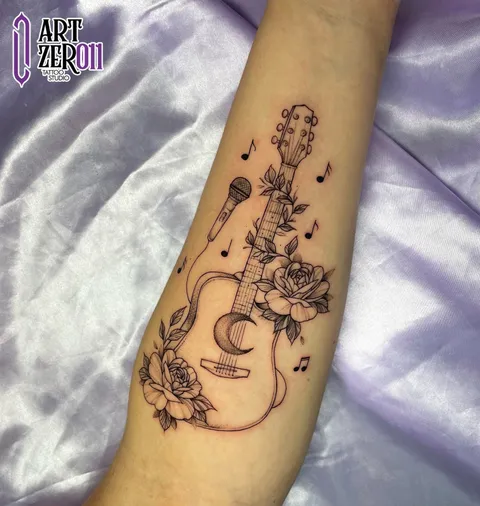 Violão com microfone, rosas e notas musicais em traço fino, no antebraço
