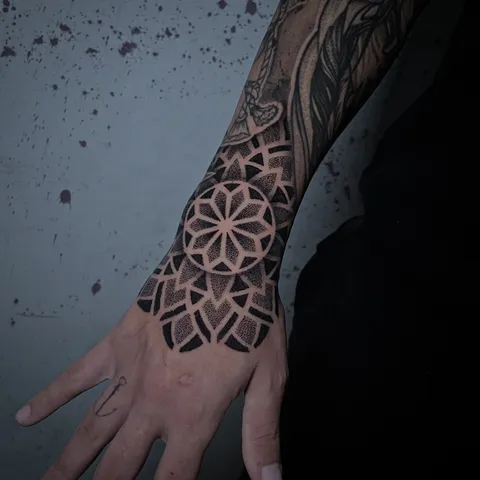 Mandala em pontilhismo no dorso da mão, subindo pelo punho