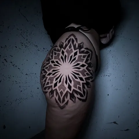 Mandala geométrica em pontilhismo preto no ombro