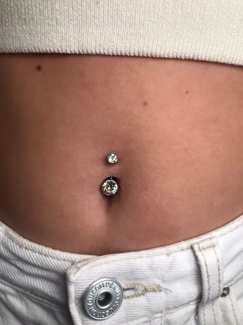 Piercing no umbigo com duas pedras brilhantes